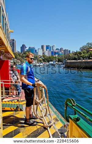 SYDNEY,AUSTRALIA - OCTOBER 19,2014: A deckhand prepares to throw the mooring rope as one of Sydney\'s iconic ferries approaches Neutral Bay Wharf.