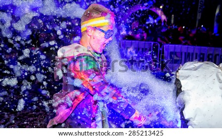 SYDNEY,AUSTRALIA - JUNE 6,2015: A boy in the Color Run Night 5K fun run. Runners encounter bubble blowers, coloured powder and UV light, joining a dance party at the finish.