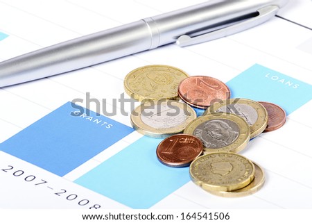 Financial scene with graphs, coins and pen