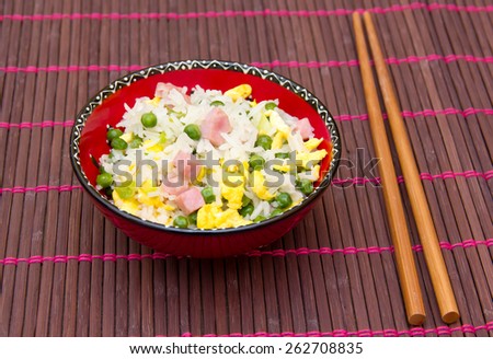 Cantonese rice with chopsticks on bamboo tablecloth