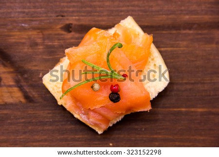 Smoked salmon on toasted bread on wooden table top