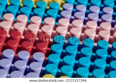 children's play background: the plane of plastic multi-colored bricks, blur, selective focus 