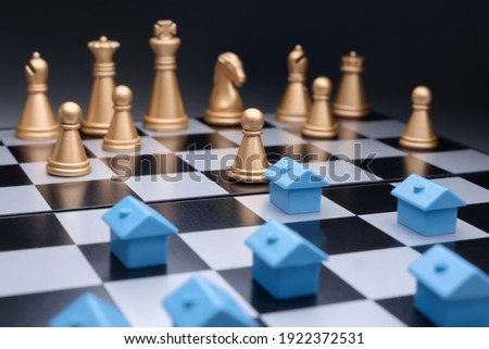 Model house real estate business strategy game chess property home mortgage marketing plan competition. Blue miniature houses property development strategy planning on chess board. Property management