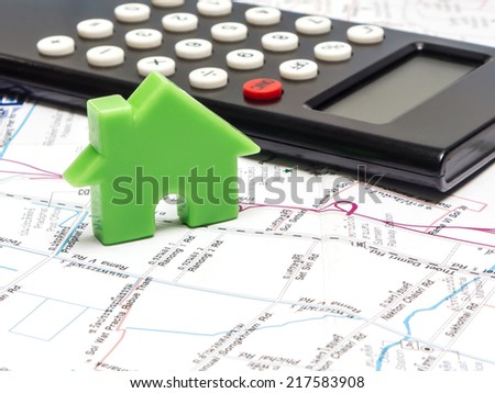 Green house and calculator on the map , property concept