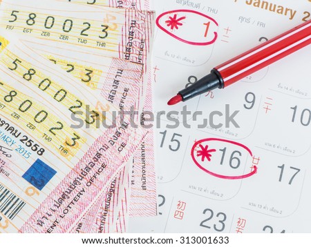 Close up Thai lottery tickets and Thai calendars with red marked of check out lottery date.
