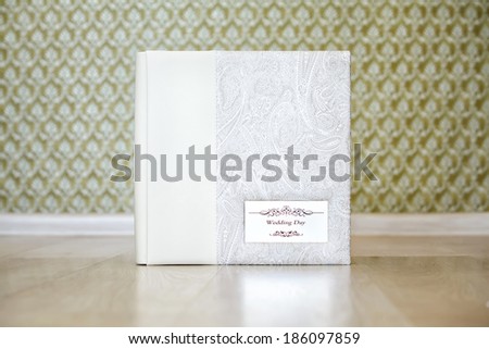 Wedding photo book with combined ivory leather cover and metal shield with title \