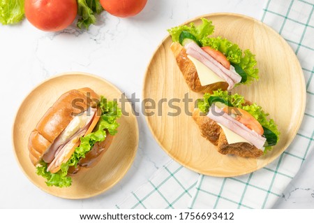 Delicious croissants sandwich with fresh Ham, cheese, tomato, cucumber, lettuce and Sub sandwich with fresh salad, Ham , cheese on white background. Top view with copy space. Flat lay.