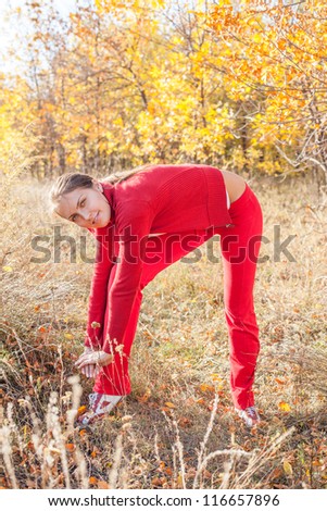 Young woman stretching before her run outdoors on a cold fall/winter day