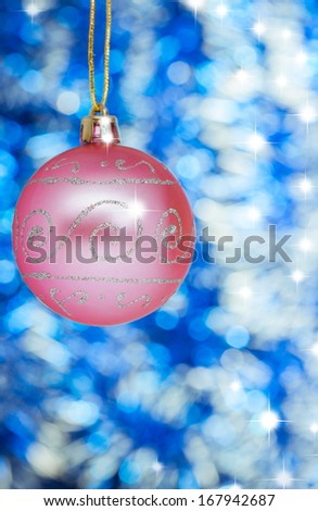 Pink New Year balls against blue shine background. Space for text