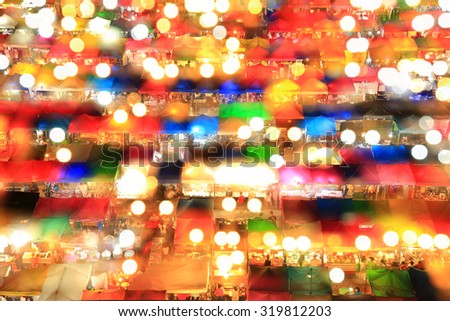 Multi-colored tents /Sales of second-hand at train night market with double exposure - soft focus