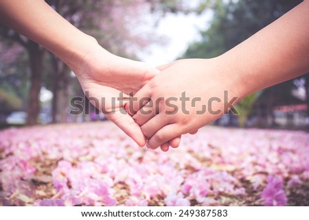 Vintage clasping hand on pink flower background