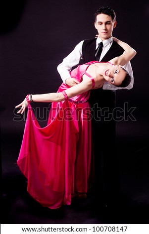 a couple dancing against black studio background