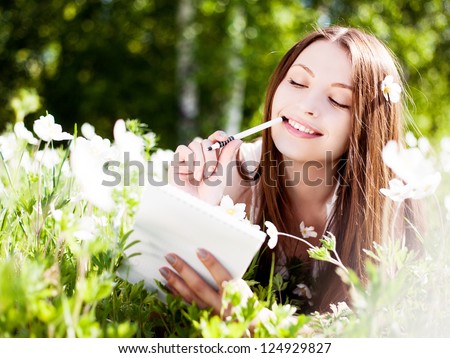 https://image.shutterstock.com/display_pic_with_logo/199288/124929827/stock-photo-beautiful-young-brunette-woman-writing-in-her-diary-on-the-meadow-with-white-flowers-124929827.jpg