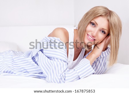 beautiful young woman wearing pajamas in bed at home