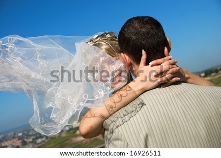 groom and bride with a flying veil outdoor