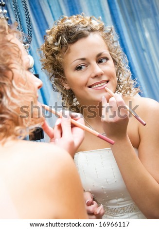 pretty smiling bride near the mirror