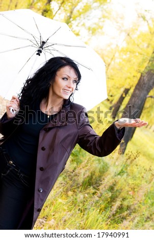happy girl with an umbrella in the park checks if it is raining