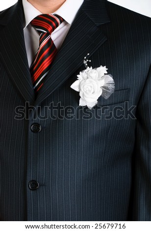 white flower decorating the costume of a groom at the wedding ceremony