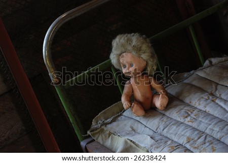 pour childhood, old dirty doll sitting on the rusty iron bed