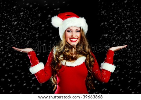 sexy young woman dressed as Santa catching snow falling on her
