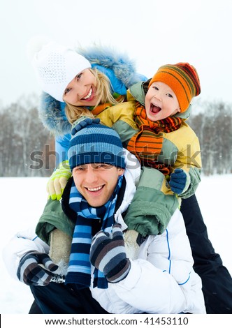 happy young family spending time outdoor in winter park