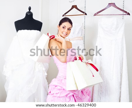 pretty young woman is choosing a wedding dress in the shop