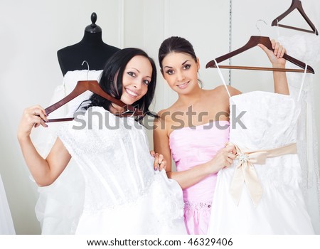 pretty young women  choosing  wedding dresses in the shop