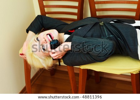 young attractive businesswoman in the office on the chairs talking on the phone