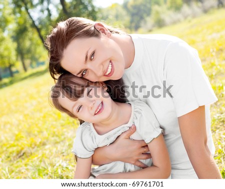 young mother and her daughter in the park on a sunny autumn day