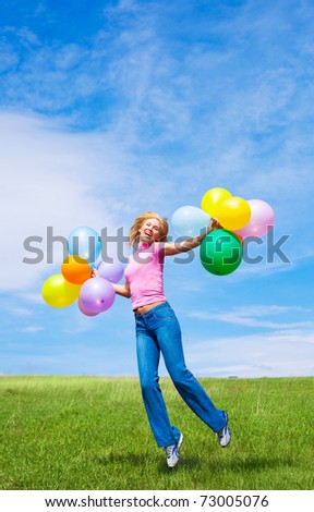 happy jumping young woman with balloons outdoor on a summer day