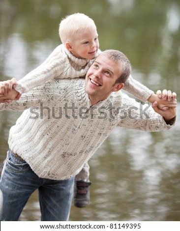 happy  family; young father and his five year old son near the lake outdoor on a summer day (focus on the man)
