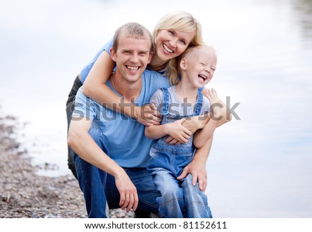 happy young family  near the lake outdoor on a summer day (focus on the man)