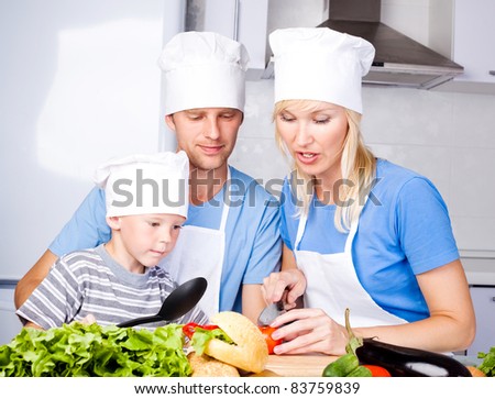 young family; father, mother and their five year old son cook together in the kitchen at home