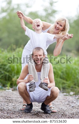 happy young family  near the lake outdoor on a summer day (focus on the man)