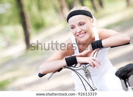 beautiful young blond woman  riding a bicycle on a warm summer day