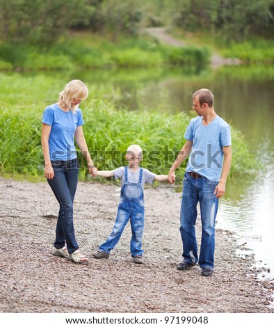 happy family  having a walk near the lake  outdoor on a summer day