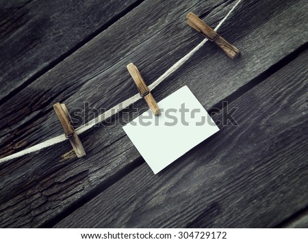 rope with clothespins and a piece of paper against old wood background, place your text here