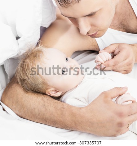 father and his two months old baby, in bed at home