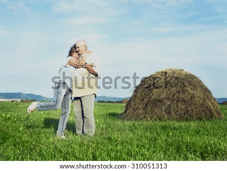 happy smiling couple: sixty eight year old man and sixty five year old woman isolated against blue background