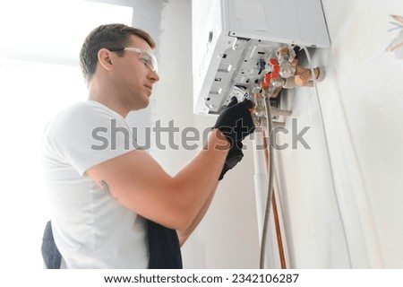 Similar – Foto Bild Arbeiter bei der Installation von Rohren mit Schraubenschlüssel in der Werkstatt