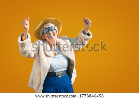 Happy and playful senior woman having fun - Portrait of a beautiful lady above 70 years old with stylish clothes, concepts about senior people and elderly age