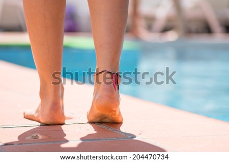 girl walking on the side of the swimming pool