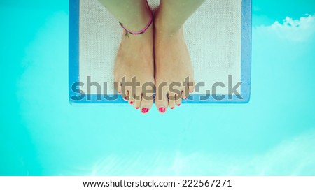 girl feet on a springboard. She is ready to jump in the water. view from above
