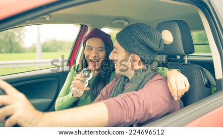 happy couple in the car. girlfriend is singing while man is driving. concept of happiness and carefree