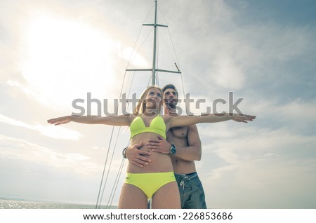 couple playing on the boat. they re acting as a popular movie. the boy holding the lady, and she opens the arms