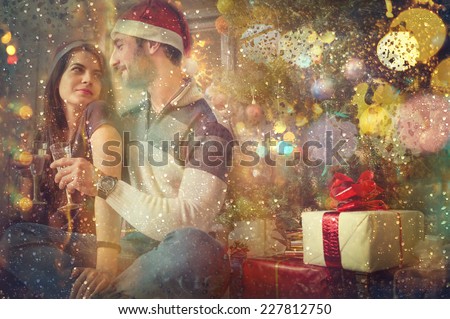 Christmas. Couple of lovers toasting champagne glasses and celebrating Christmas and New Year holiday.View from outside the window,rain on the glass.