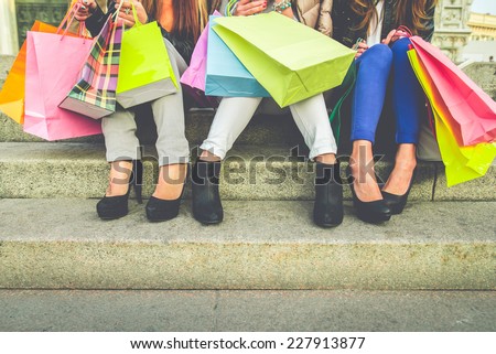 Women with high heels and shopping bags - Three girls sitting on stairs and chatting after buying presents