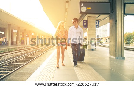 couple at the train station. man need to take a train and his girlfriend is saying goodbye