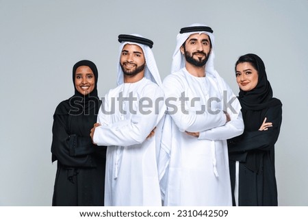 Beautiful arab middle-eastern women with traditional abaya dress and middle easter man wearing kandora in studio - Group of arabic muslim adults portrait in Dubai, United Arab Emirates Foto stock © 