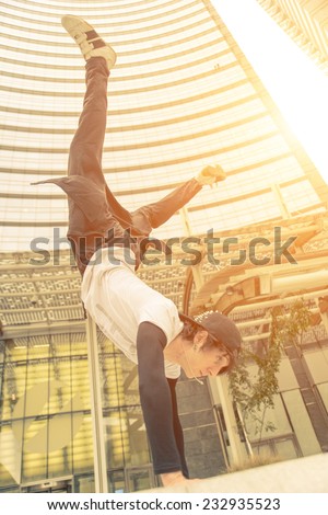 vertical action move in business center. young boy performing parkour moves.